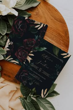 the wedding stationery is laid out on a table with flowers and greenery around it