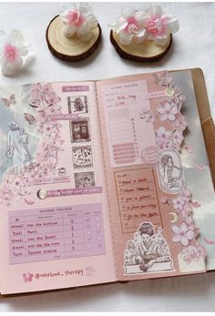 an open book with pink and white flowers on it, next to some small cookies