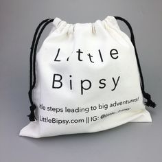 a white bag with the words little bipsy printed on it and black string