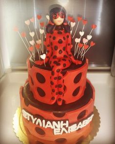 a red and black cake with a lady bug on top