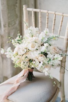 a bouquet of white flowers sitting on top of a chair