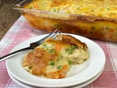 a white plate topped with food next to a casserole dish