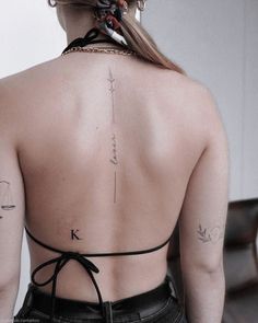 the back of a woman's neck with tattoos on it