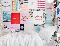 a bedroom with white bedding and lots of posters on the wall