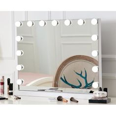 a vanity mirror with lights on top of it and various makeup items in front of it