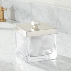 a glass soap dispenser sitting on top of a white marble countertop