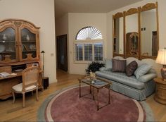 a living room filled with furniture and a large mirror