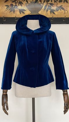 "This late 1950s to early 1960s jacket is made from a deep blue coloured cotton velvet, the velvet is quite soft and silky to the touch. It is lined in a synthetic satin type fabric and is labelled 'Sydney Model' to the inside. This can be worn buttoned or unbuttoned and with the collar up or down as shown in the listing photos. It has self-covered buttons to the front and a spare button still attached to the inside.  When laid flat and fastened the measurements are: Length: 23\" inches  From underarm to underarm across: 17.5\" inches Across the waist: up to 15\" inches Sleeve length: 21\" inches From shoulder seam to shoulder seam across: just under 15\" inches It is in very good overall condition, there is some discolouration to the lining at the bottom of the jacket, at the inside neck Blue Velvet Winter Outerwear, Vintage Velvet Party Outerwear, Vintage Blue Outerwear For Party, 1960s Jacket, The Velvet, Velvet Jacket, Jacket Vintage, Cotton Velvet, Covered Buttons