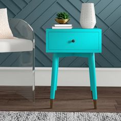 a blue table with a potted plant sitting on it next to a white chair