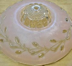 a pink glass bowl sitting on top of a wooden table