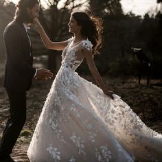 a man in a suit and tie standing next to a woman in a wedding dress