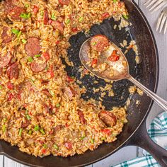 a skillet filled with rice and sausage