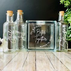 three empty glass bottles sitting on top of a wooden table