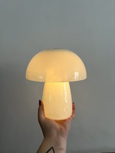 a person holding a mushroom lamp in their hand