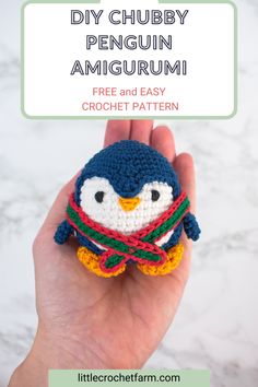 a crocheted penguin amigurm is shown in front of a white marble background