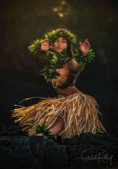 a woman in a hula skirt is posing for the camera with her hands up