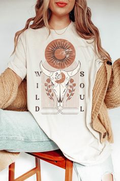 Unleash your untamed spirit and embrace a fusion of vintage vibes and bold individuality with our Retro Wild Soul Oversized Graphic Tee. The design is a captivating blend of elements, a rustic cow skull adorned with intricate detailing, distressed textures, and a pop of retro-inspired hues. It's a visual representation of the untamed spirit within, a fusion of rugged and refined. Whether you're a lover of all things vintage, an advocate of personal expression, or someone who embraces their wild Graphic Tee Style, Distressed Texture, Oversized Graphic Tee, Cow Skull, Bella Canvas Tees, The Untamed, Graphic Tops, Boho Designs, Vacation Shirts