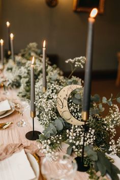 the table is set with candles, plates and napkins for an elegant wedding reception