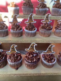 cupcakes decorated with chocolate frosting and witches hats are on display for sale