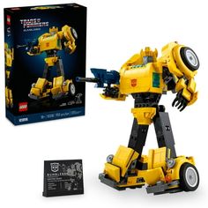 a yellow and black lego robot next to a box