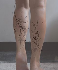 the legs and ankles of a woman with tattoos on her body are decorated with flowers