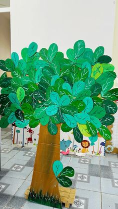 a paper cut out of a tree with leaves on the top and bottom, in front of a tiled floor