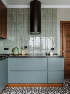 a kitchen with blue cabinets and black counter tops in front of a stove top oven