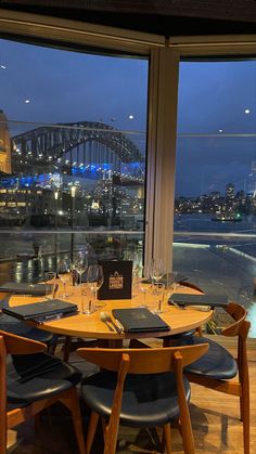 a dining room with a view of the sydney harbour bridge and opera house at night