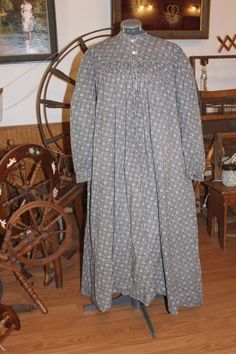 an old fashioned dress is on display in a room with spinning wheels and other items