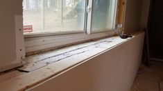 an empty window sill in the corner of a room that is being remodeled with paint and tools