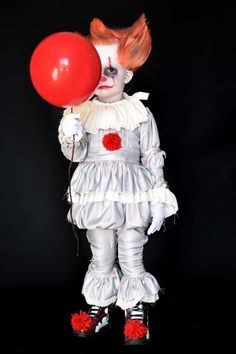 a creepy clown holding a red balloon