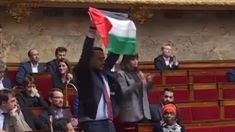 a man holding up a flag in front of an audience