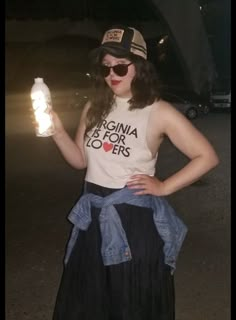 a woman in a white shirt and black skirt is holding a bottle with light on it