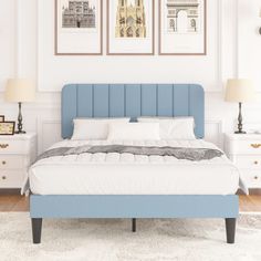 there is a bed with blue headboard and two pictures on the wall above it