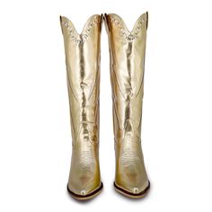 The Jolene, cowboy boots with an eye catching blend of elegance and edginess. The gold hue and striking silver lightning bolts set them apart in any collection. The bold gold color adds a little western charm and the silver lightning bolt add a contemporary, electrifying twist. Whether you're dressing up for a night on the town or seeking to add a touch of individuality to your everyday attire, "The Jolene" is your perfect companion. Material: Vegan Leather Minnie Pearl, Scalloped Collar, Lightning Bolts, Lightning Bolt, Tall Boots, Western Boots, Cowboy Boots, Knee High, Vegan Leather