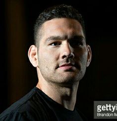 a close up of a person wearing a black shirt and looking off to the side