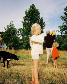 three children and two dogs playing in the grass