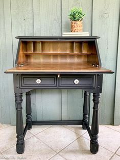 an old desk with a potted plant on top