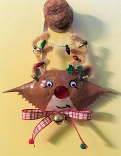 a reindeer head hanging on the wall next to a wine bottle with christmas decorations around it