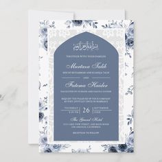 a blue and white wedding card with floral designs on the front, featuring an ornate arch