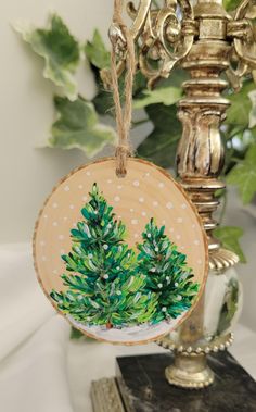 a wooden ornament with a green tree painted on it