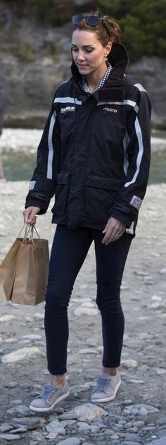 a woman in black jacket carrying shopping bags