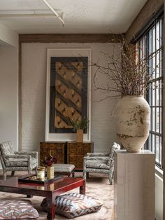 a living room filled with furniture and a large vase