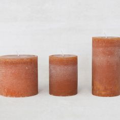 three candles sitting next to each other on a white surface