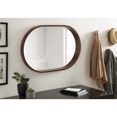 a mirror hanging on the wall next to a coat rack