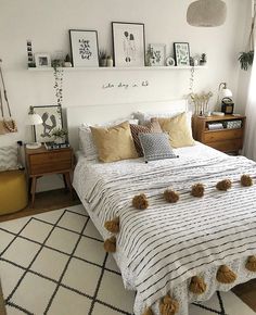 a bedroom with white walls and lots of pictures on the wall