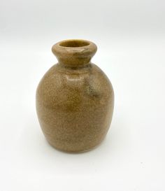 a brown vase sitting on top of a white table