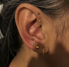 a close up of a person's ear with three different piercings on it