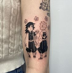 a person with a tattoo on their arm that has an image of two people standing next to each other