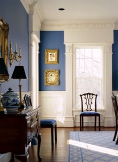 a living room with blue walls and white trim